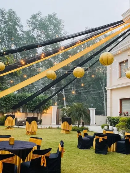 Another view of the black and gold themed event, showing the combination of round tables and high top cocktail tables. This layout provides varied seating options for guests at a large corporate function.