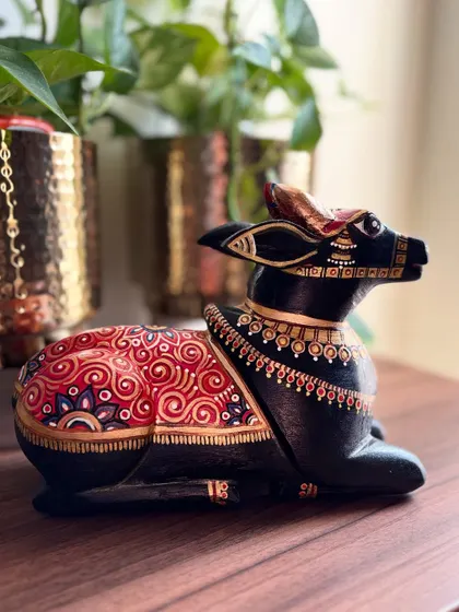 A side profile of the seated Nandi, showing the flow of the hand-painted ornamentation along its back. This piece is designed to be beautiful from every angle.