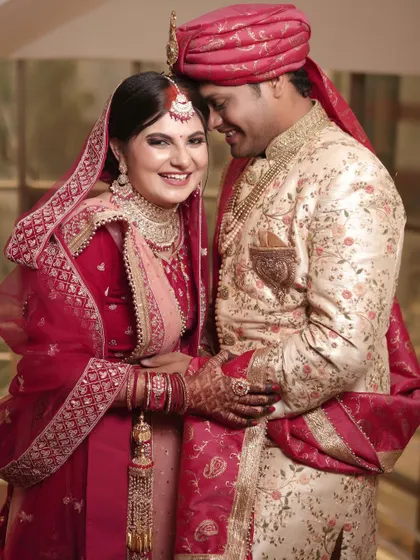 A beautiful, happy portrait of the newlyweds. The bride's bright smile and the couple's warm embrace make this a perfect memory of their special day.