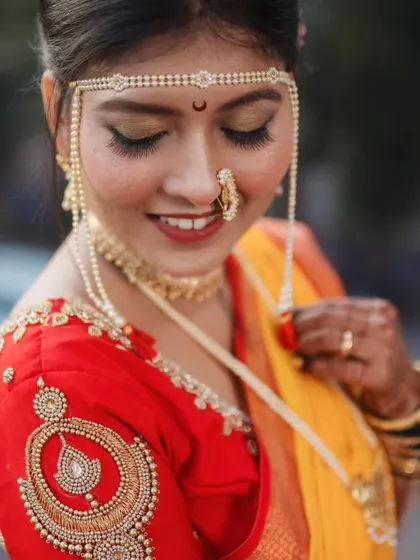 A close-up portrait focusing on the bride's expressive eyes and the traditional mundavalya on her forehead.
