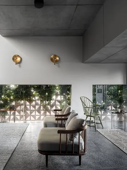 We designed a long, eye-level cutout window that runs the length of the living room, offering curated glimpses of the garden greenery. This feature, combined with the fully opening doors, ensures the space is always filled with natural light and views.