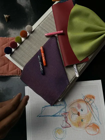 A creative flat lay of drawing and fabric samples.