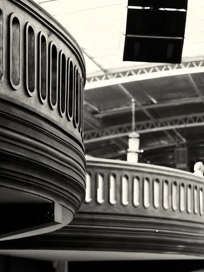 The repeating curves of the balconies create a sense of rhythm and movement throughout the large venue.
