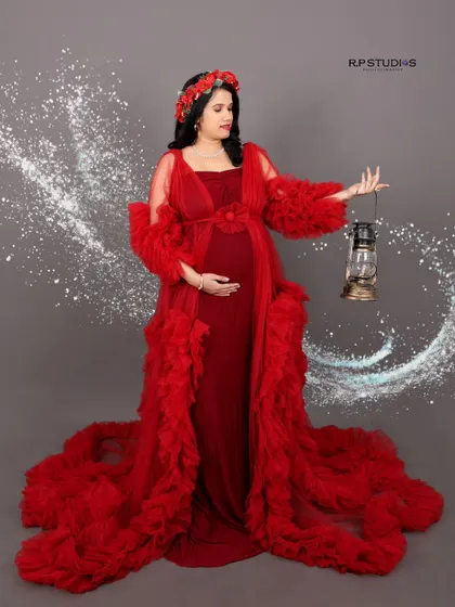 We use creative props and effects to add a touch of magic. This mom-to-be holds a vintage lantern while a swirl of light surrounds her, enhancing the drama of her beautiful red gown.
