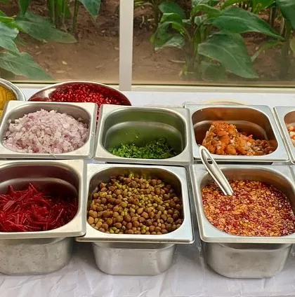 A close-up of the fresh ingredients at our chaat counter. We provide everything from chopped onions and tomatoes to chickpeas, chutneys, and sev.