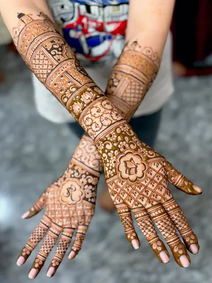 A different pose of the "R" initial mehendi, showing how the design looks from another angle.