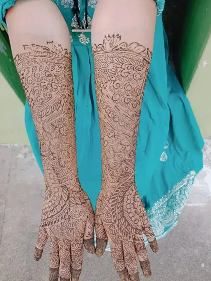 A beautiful example of a full bridal mehendi, with dense patterns covering the hands and arms completely. The design is rich and traditional.