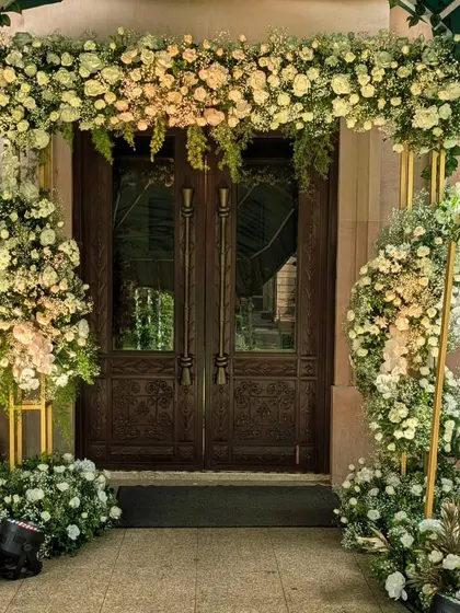 A floral archway is a classic symbol of welcome. For Andrea and Vrushank's ceremony, I designed this lush entrance with white and blush roses, creating a soft and romantic gateway for their guests.