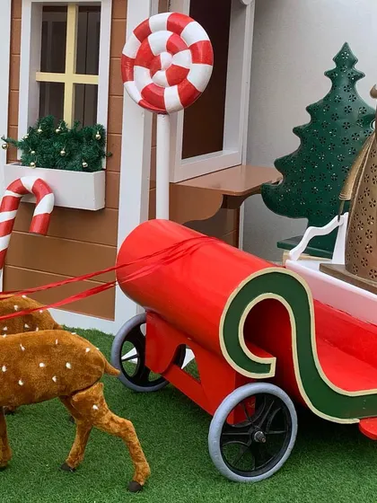 Santa's sleigh, pulled by two of his reindeer, is ready for deliveries. This is a classic and beloved prop for any Christmas event.