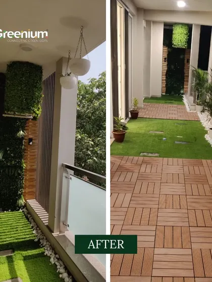 The "after" shot of the balcony garden transformation. The space now features a mix of wooden deck tiles and artificial grass, a vertical garden, and hanging planters, creating a beautiful and functional outdoor area.