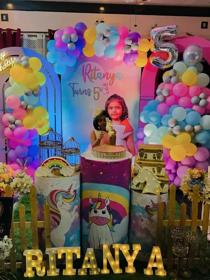 I love making parties personal. This unicorn-themed celebration for a 5th birthday features a custom backdrop with the child's photo, colorful balloon garlands, and their name in large, light-up marquee letters, creating a magical and unique focal point.