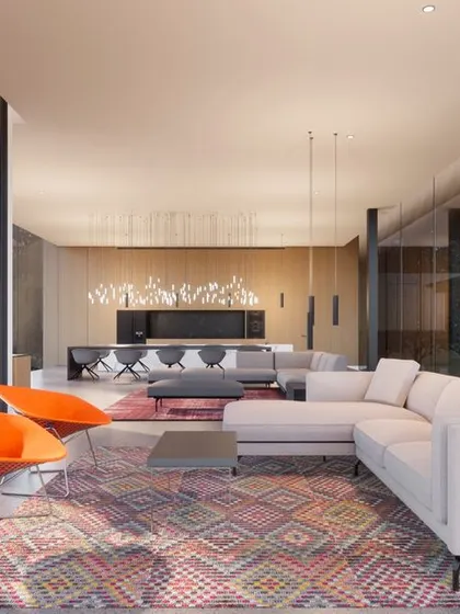 The interior of the Janwada farmhouse. The open plan living space, with its simple furniture and large glass walls, is designed to be a humble backdrop, allowing the views of the landscape to be the main focus.