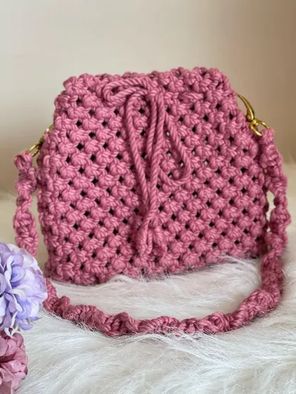 This lovely onion-pink bag features a classic net-style knot and a secure drawstring closure. The twisted macrame strap is both durable and comfortable on the shoulder.