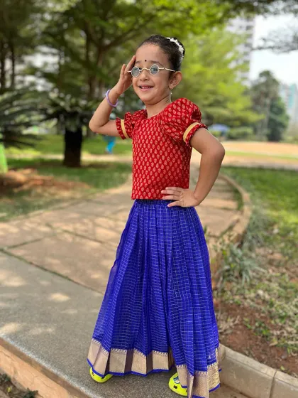This little "Singari" is ready for her close-up. Dressed in a beautiful Pattu Pavadai with a touch of modern swag in her glasses, she captures the fun spirit of our classes.