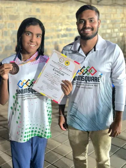 Prachita Deb celebrates her double bronze medal win in the 100m and 200m Butterfly events at the NRJ State Aquatics Championship, holding her certificate of achievement.
