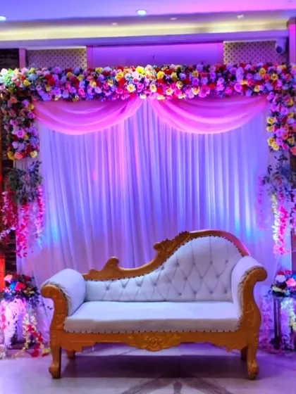 This full view of the stage highlights the balance of the floral decor, the elegant draping, and the comfortable seating, creating a perfect photo opportunity.