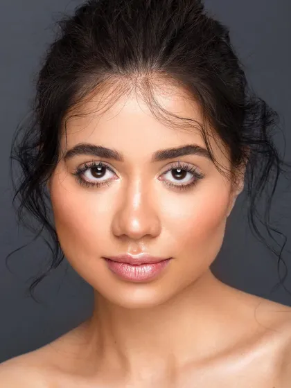 A direct and engaging headshot. The model's eyes connect with the viewer, and the clean, simple styling makes this a perfect example of a timeless and versatile beauty portrait.