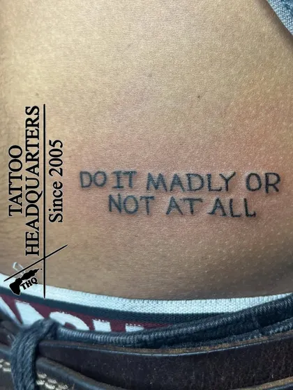 The motivational quote "DO IT MADLY OR NOT AT ALL" in a simple, impactful font, placed on the lower back.