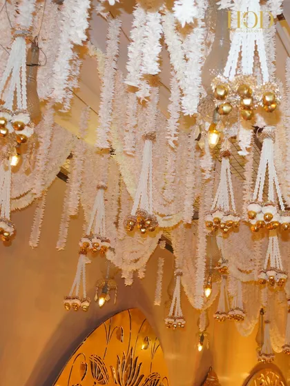 Another detail of the hanging floral chandeliers, with the light catching the golden bells and creating a warm, sparkling effect.