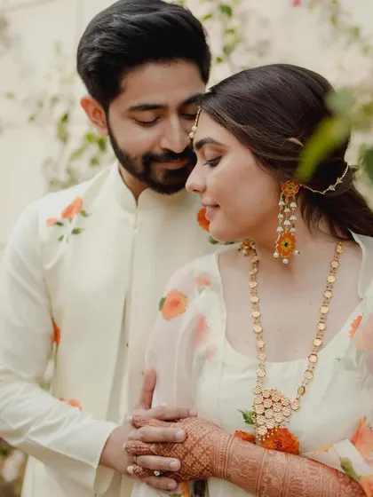 An intimate portrait of the couple during their Haldi ceremony, their floral-printed outfits perfectly complementing the sunny, joyful theme.