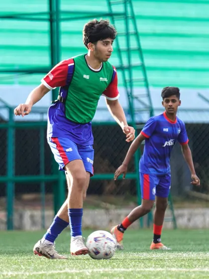 A player shields the ball from a defender, demonstrating strength and game awareness. We teach players how to use their bodies effectively to maintain possession.