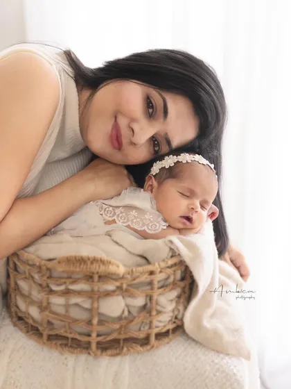 A mother rests her head lovingly next to her sleeping baby. This peaceful and intimate portrait captures the deep connection and serenity of motherhood.