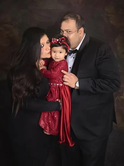 Sweet kisses for their little girl. This photo is overflowing with love and affection, a perfect capture of this family's bond.