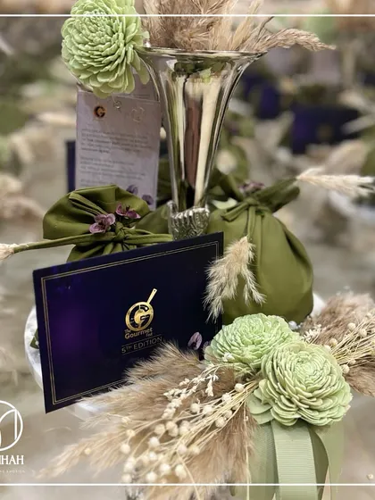 This shot captures the beautiful contrast between the silver vase, the dark purple of the invitation card, and the soft, natural tones of the pampas grass and flowers.