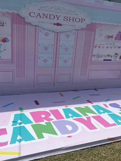 A sneak peek of a custom "Ariana's Candyland" photo booth backdrop before the party begins.
