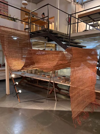 Our studio is a space of material alchemy. This image captures the process behind our 'Cu+Fibers' exhibition, a play of handspun and machine-made yarns. The journey of coaxing, manipulating, and responding to hemp, jute, and copper is a continuous engagement guided by the joy of small discoveries.