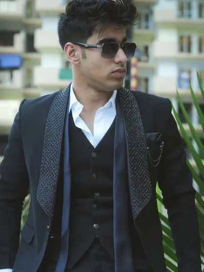 A side profile of the black suit, highlighting the fit and the sunglasses that complete the cool look.