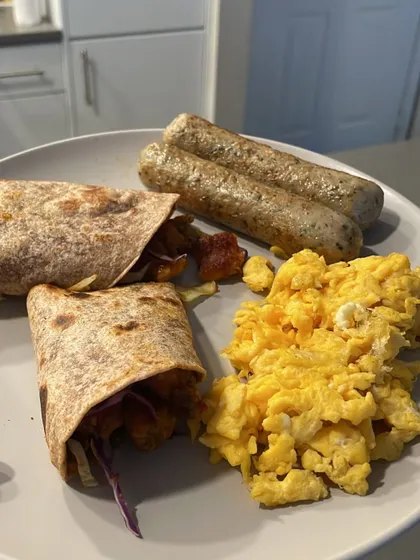 A satisfying breakfast that will keep you full and energized for hours. This plate has it all: protein from scrambled eggs and sausages, and complex carbs from the whole-wheat wrap. This is what a balanced, real-world meal looks like.
