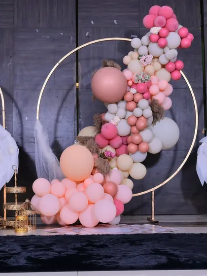 A detailed look at the organic balloon garland from the baptism decor, showing the mix of different sizes and shades of pink and peach.