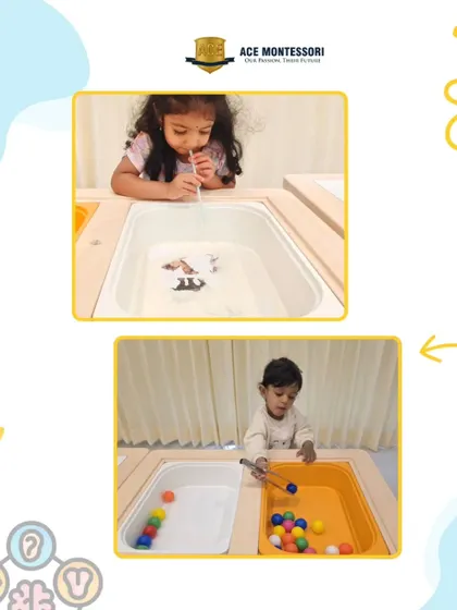 This sensory station combines multiple activities. One child uses tongs to move pom-poms, developing pincer grasp, while another explores blowing objects across the water, learning about air and movement.
