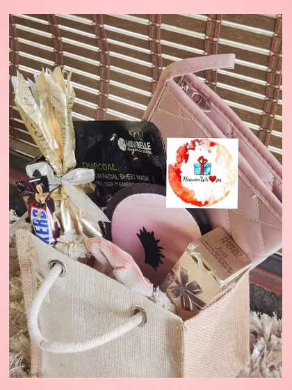 A rustic and chic hamper in a canvas tote bag. This gift is filled with a mix of treats and self-care products, including a charcoal face mask and a Snickers bar, offering a little bit of everything.