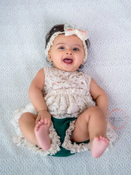 A happy baby on her back, kicking her feet with joy. These playful, natural poses make for the best milestone photos.