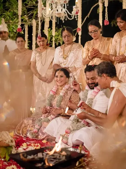 The couple surrounded by family as they participate in the sacred rituals of their traditional Bunt wedding.