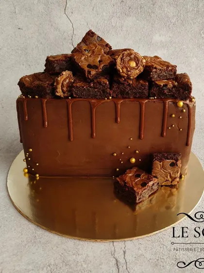This semi-circle cake is a chocolate explosion. It's a 1 kg Ferrero Crunch cake with a ganache finish, Nutella drip, and a generous pile of my homemade Nutella brownies on top.