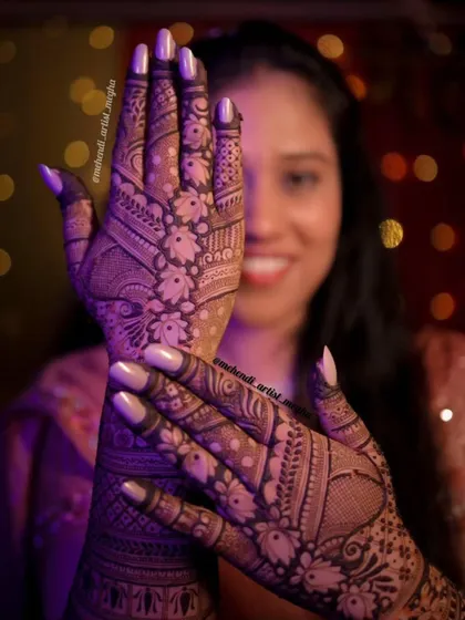 A beautiful shot of a client showing off her floral and paisley mehendi. The joy on her face reflects the beauty of the art on her hands.