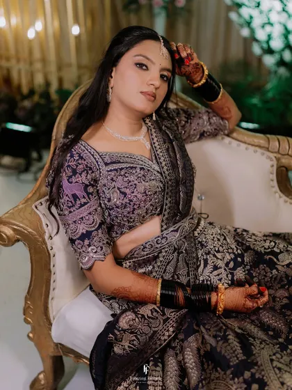 A regal portrait of the bride seated on a gilded chair, her intricate lehenga and confident pose creating a powerful image.