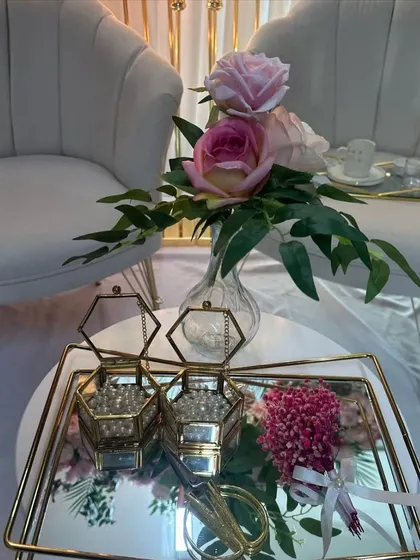 A close-up of the detailed decor for a Roka ceremony, including ornate ring boxes and a small floral arrangement on a mirrored tray.
