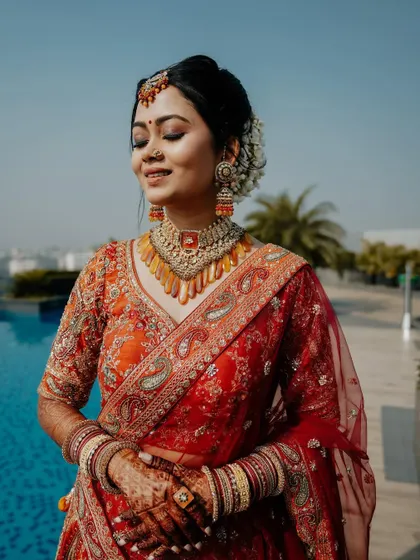 A joyful, sun-kissed portrait. The bride's happy smile and the bright, outdoor setting by the pool create a feeling of pure bliss and celebration.