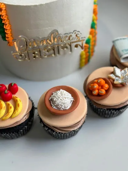 Matching cupcakes for the Annaprashan ceremony, decorated with miniature traditional food items.