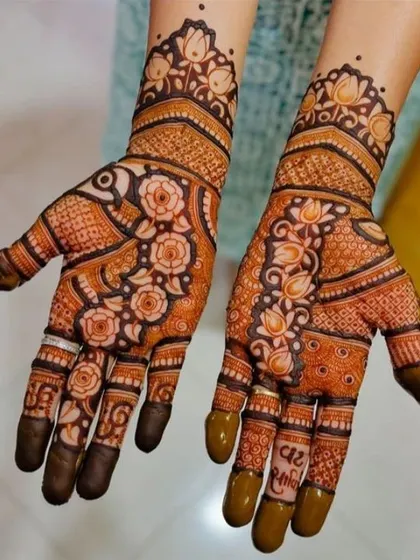 A beautiful example of a floral vine pattern that flows across both hands. The shading on the roses gives them depth, and the initials hidden in the fingers add a personal touch for the client.