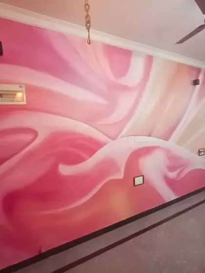 A large-scale abstract mural with flowing pink and white swirls, adding a soft yet dramatic artistic element to this living space.