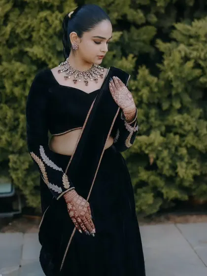 The rich texture of the black velvet is the star of this outfit. The blouse features subtle embroidery on the sleeves for a touch of detail.