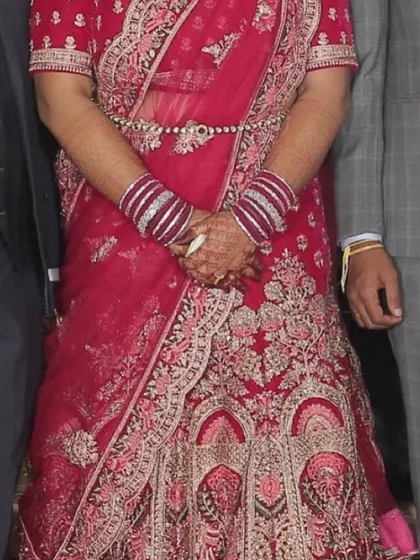 A client wearing the magenta bridal lehenga, looking absolutely regal. Renting a bridal lehenga is a smart way to get a high-end look for your wedding.