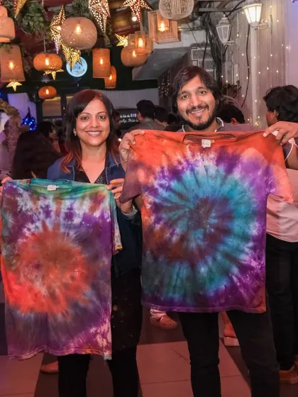 I love offering a variety of creative activities, like this vibrant tie-dye workshop. This couple is showing off the matching custom t-shirts they designed together, each a unique swirl of colors and a wearable piece of art.