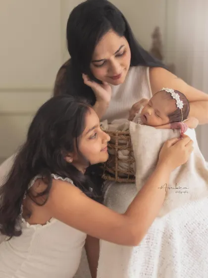 A mother and daughter admiring the family's newest addition. This multi-generational moment captures the love that surrounds a newborn baby.