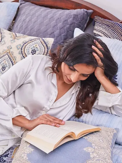 Embrace the calming embrace of blue with my Indigo collection. This lifestyle shot shows a moment of pure bliss, wrapped in the softness of my designer cushions and bedcovers.